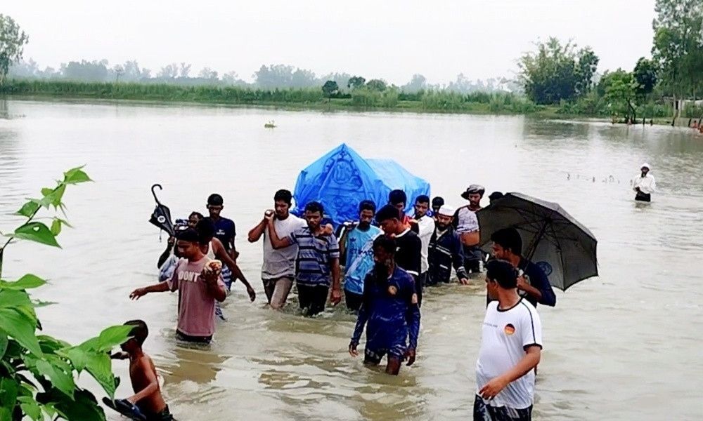 শেষ বিদায়েও দুর্ভোগ, গলা সমান পানি পেরিয়ে কবরস্থানে লাশ